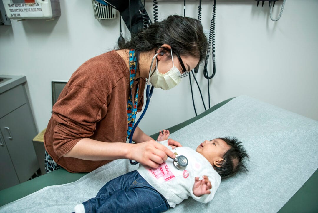 Woman helping an infant patient.